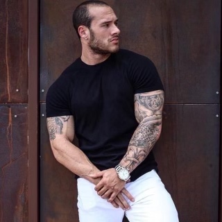 A tattooed man leaning on a wall. Nick Tognietti, a nutrition expert in Katy, TX, will rejuvenate you with weight loss, energy boost, and better sleep.